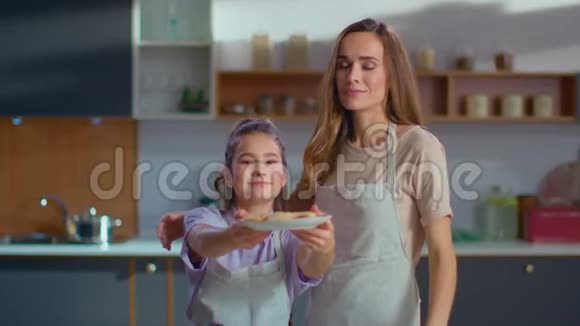 母女俩拿着盘子厨房里有自制的饼干视频的预览图