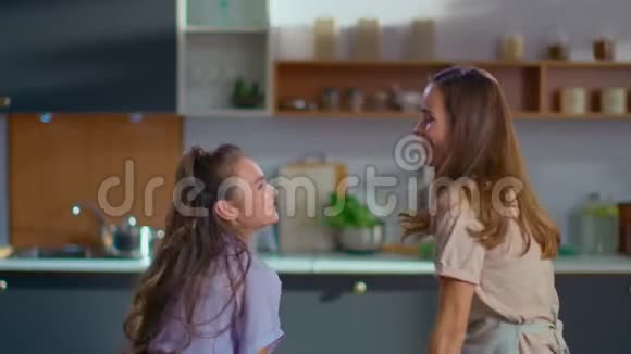 女人和女孩在厨房跳舞母女俩互相对视视频的预览图