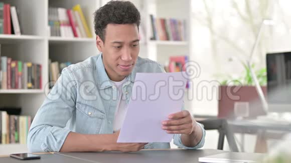 年轻的非裔美国人办公室阅读文件视频的预览图
