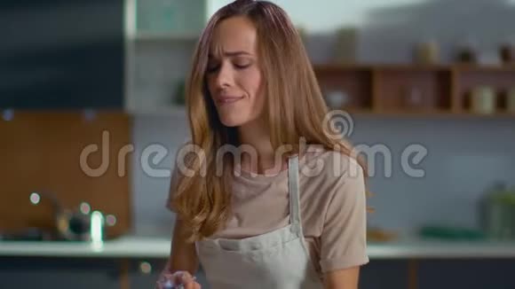 有魅力的女人在家庭厨房做饭女人在厨房用智能手机视频的预览图