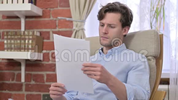 失望的年轻人阅读文件视频的预览图