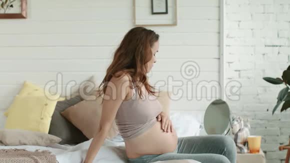 从玻璃卧室里给孕妇做特写准妈妈坐床回家视频的预览图