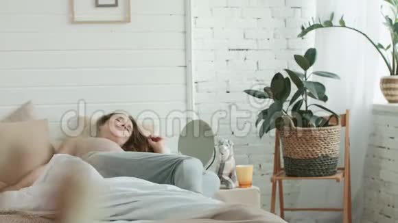 孕妇在卧室里起床特写微笑的妈妈抚摸着肚子视频的预览图