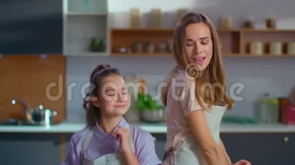 快乐的女儿和母亲在厨房里缓慢地来回跳舞视频的预览图