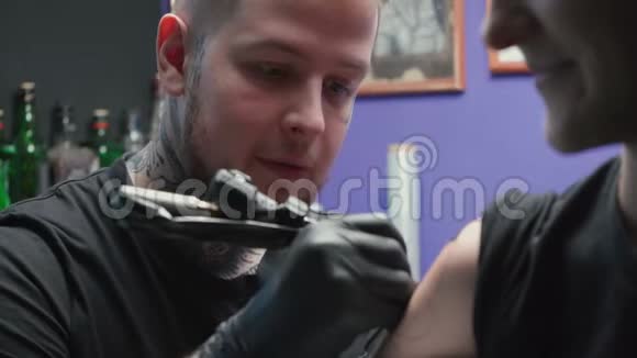 青年纹身师在沙龙中纹身蛇视频的预览图