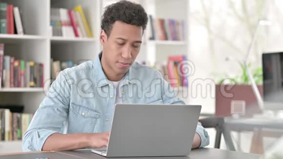 年轻的非裔美国人在工作时在镜头前微笑视频的预览图