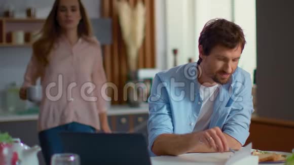 商人和女人在家里用笔记本电脑男人和女人谈论厨房视频的预览图