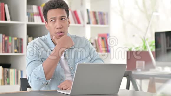 非裔美国年轻人在笔记本电脑上思考和工作头脑风暴视频的预览图
