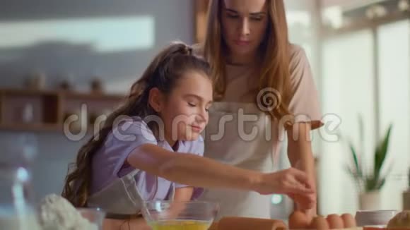 母女俩在厨房做饭一个女人在和厨房里的女孩说话视频的预览图