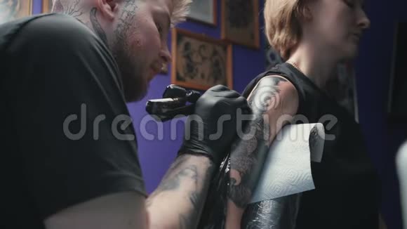 男子在工作室为妇女做蛇纹身的视频视频的预览图