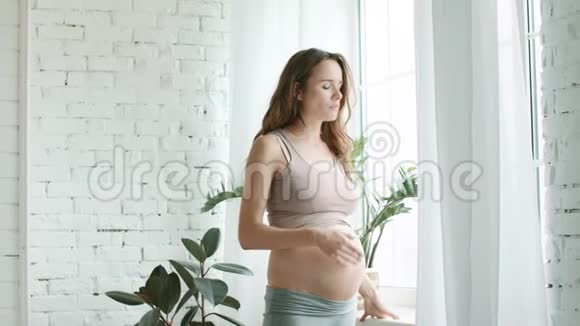 特写准妈妈感觉早上不舒服怀孕的卧室窗户视频的预览图