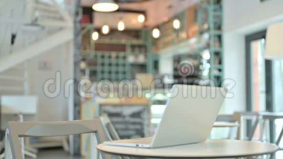 年轻女子在咖啡厅的桌面上打开笔记本电脑视频的预览图