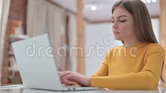 有创意的年轻女性在电脑上工作在镜头前微笑视频的预览图
