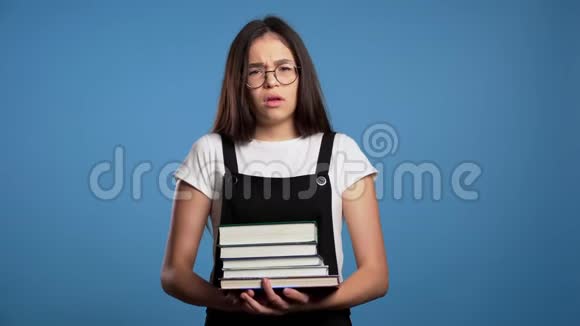 亚洲学生对大量的家庭作业和书籍感到不满有书的女孩她很生气视频的预览图