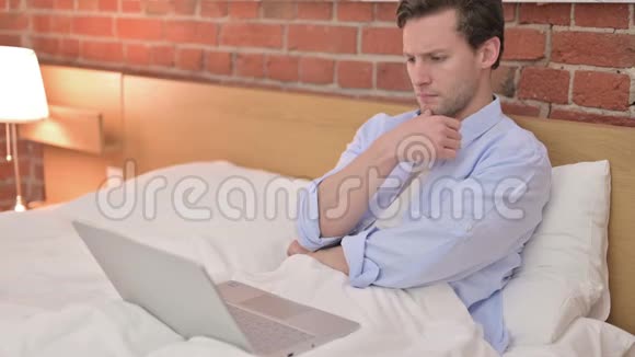 年轻人在床上思考和工作视频的预览图
