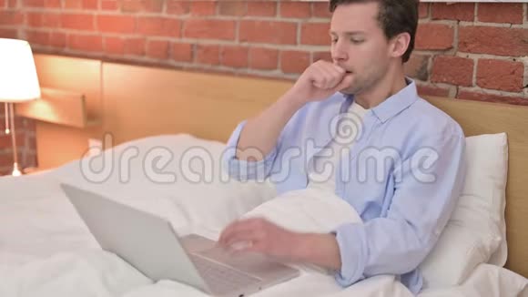 在床上工作和咳嗽的年轻人视频的预览图