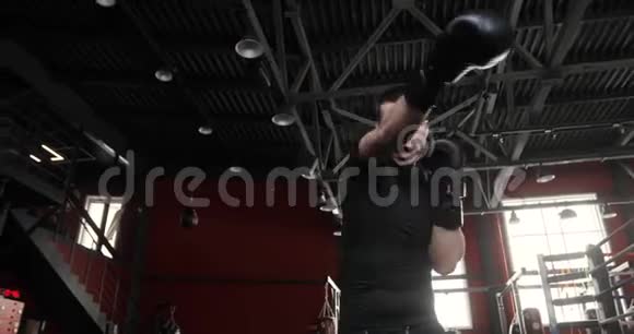 拳击手年轻男子手套拳击和看相机在健身房底部视图视频的预览图