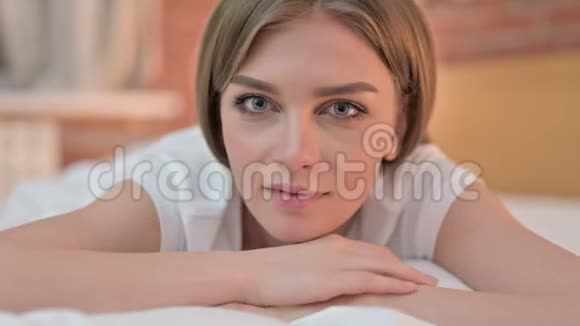 把手指放在床上的年轻女人的嘴唇上视频的预览图