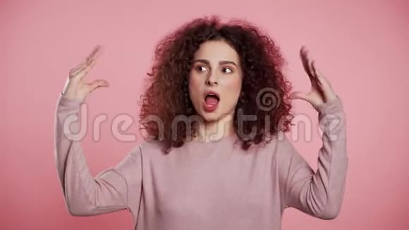 可爱的女人用双手和滚动的眼睛在粉红色用粉红色的眼睛来显示布拉的手势视频的预览图