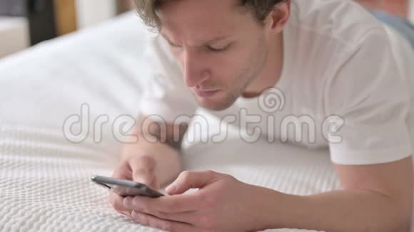 聚焦年轻人在床上使用智能手机视频的预览图