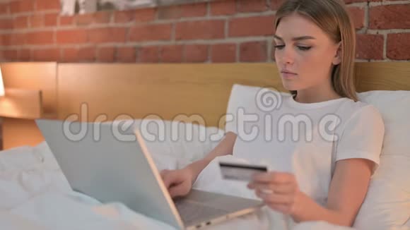 年轻女性在笔记本电脑上庆祝网上支付成功视频的预览图