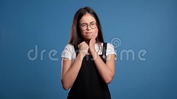 年轻漂亮的亚洲女人在蓝工作室背景下牙齿疼痛牙痛牙齿问题视频的预览图