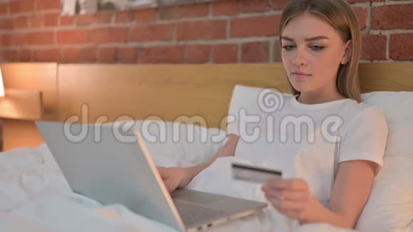 网上支付床上笔记本电脑的年轻女子视频的预览图