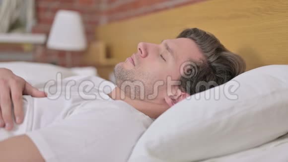 年轻人醒来离开床的肖像视频的预览图