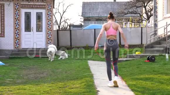 女运动员在家跳绳积极健身女性在户外做运动健身理念视频的预览图