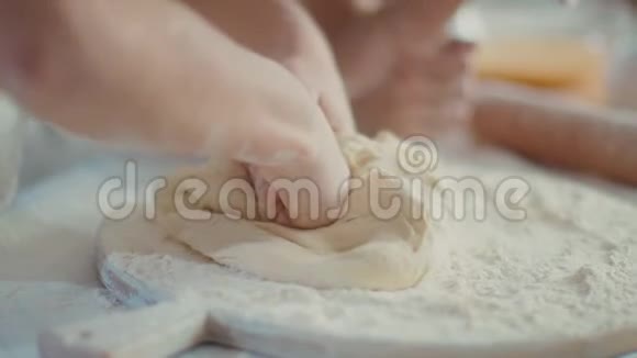 女人帮女儿在厨房桌子上揉面团视频的预览图