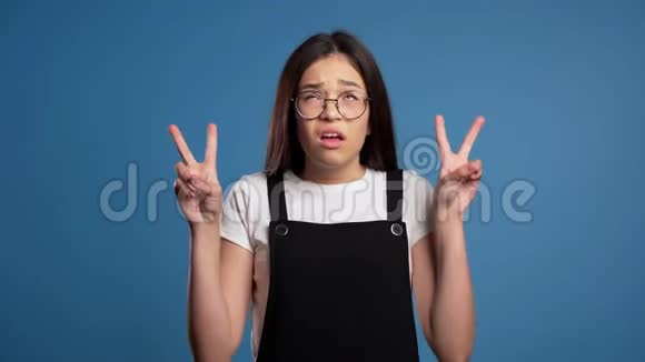亚洲女孩用双手和两个手指像引号一样的手势把手指弯曲孤立在蓝色上视频的预览图