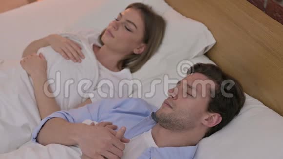 在床上打盹的漂亮年轻夫妇视频的预览图