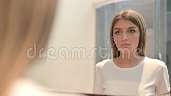 严肃的年轻女性在镜中的后景视频的预览图