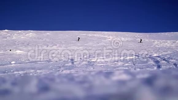 两个滑雪者在一个山脉的背景下降落在一个雪坡上在大雪纷飞的冬天危险的自由视频的预览图