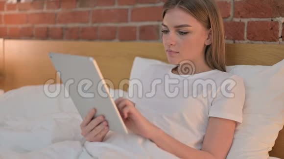 失望的年轻女性对床上药片损失的反应视频的预览图