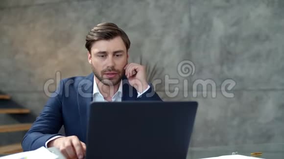 严肃的商人在笔记本电脑上做网络会议一个说网络摄像机的人视频的预览图