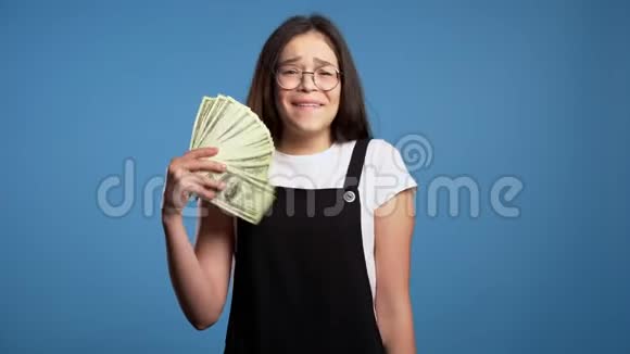 满意的高兴兴奋的亚洲女孩展示金钱美元钞票视频的预览图