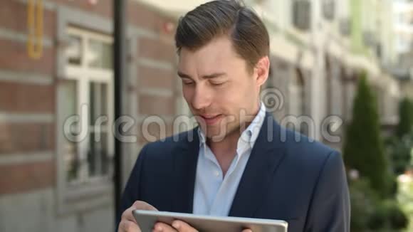 特写商人在户外浏览互联网在街上拿着触摸板的男人视频的预览图