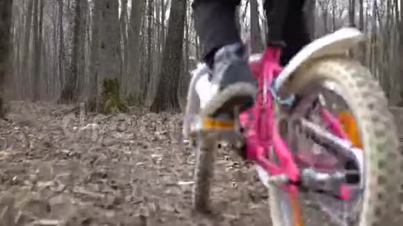 骑自行车的女孩穿着秋装穿过树林视频的预览图