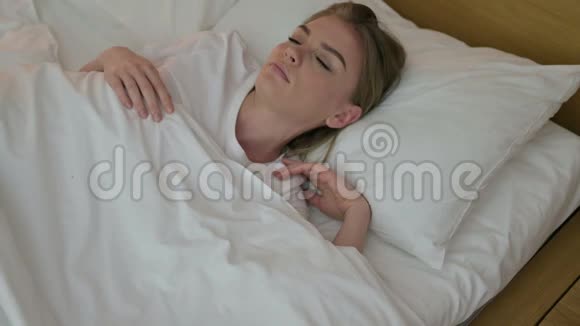 迷人的年轻女子试图睡在床上视频的预览图