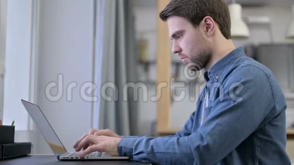 大胡子年轻人在笔记本电脑上庆祝成功视频的预览图