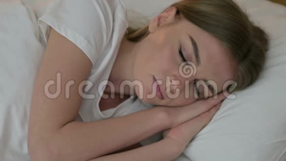 试图睡在床上的年轻女人的画像视频的预览图
