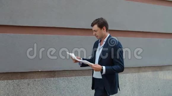 严肃的商人阅读文件带着文件走在街上的男人视频的预览图