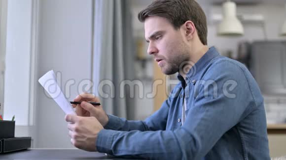 大胡子青年在办公室阅读文件视频的预览图