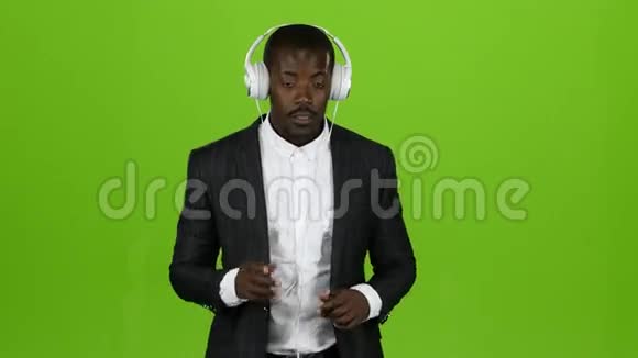 黑人非洲男子通过耳机听音乐并一起唱歌绿色屏幕视频的预览图