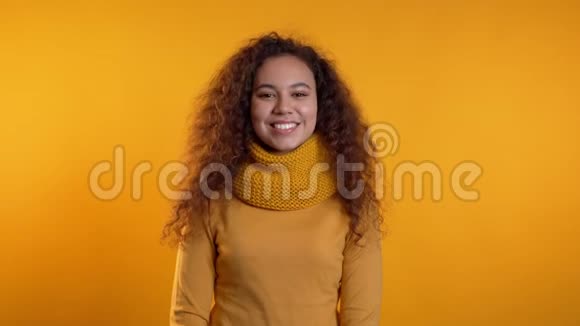 年轻的卷发女人完全是黄色的在演播室背景下调情美女的肖像视频的预览图