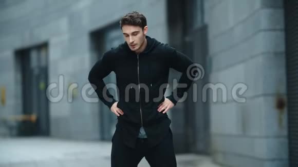 健身男子热身户外慢动作运动男在街上伸脖子视频的预览图