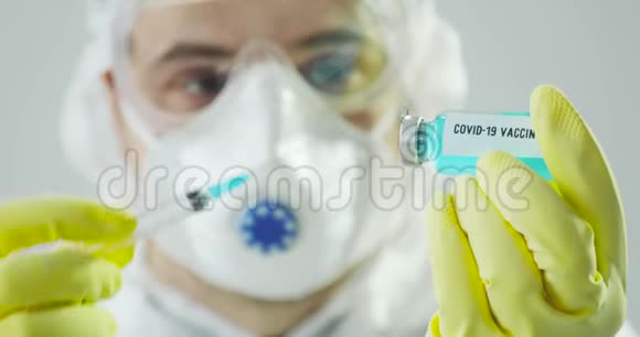 穿着防护服的医生画像用冠状病毒疫苗填充注射器视频的预览图