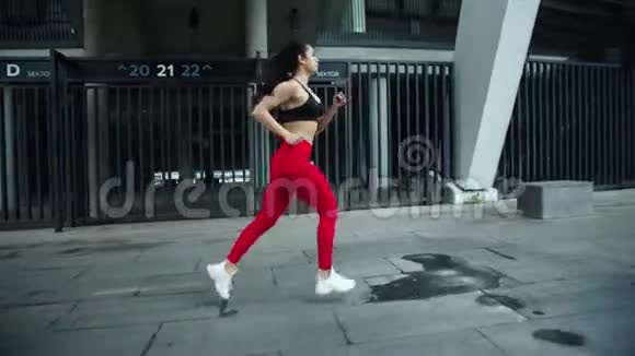 女子跑步者在户外慢动作训练健身妇女在街上奔跑视频的预览图