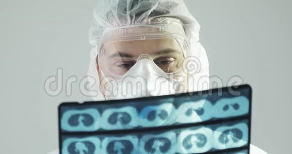 穿着防护服的医生学习大脑CT扫描图像对covid19流行视频的预览图